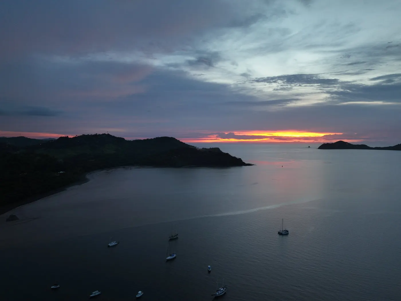 Sunset over the bay at Playas del Coco with boats at anchor
