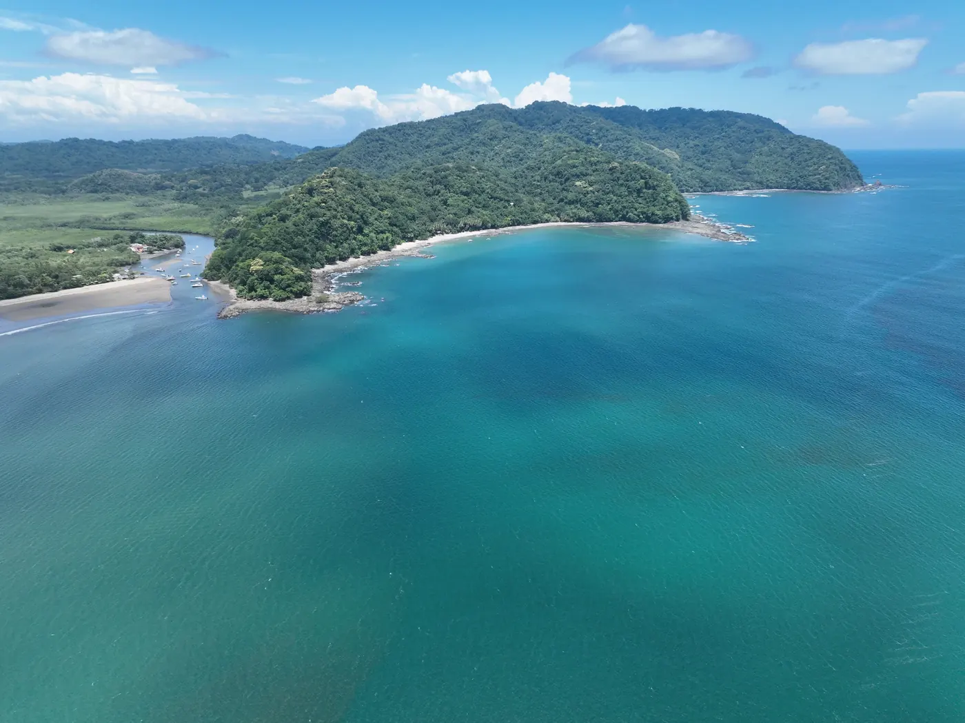 Aerial view of a bay with a forested headland at Playa Ocotal